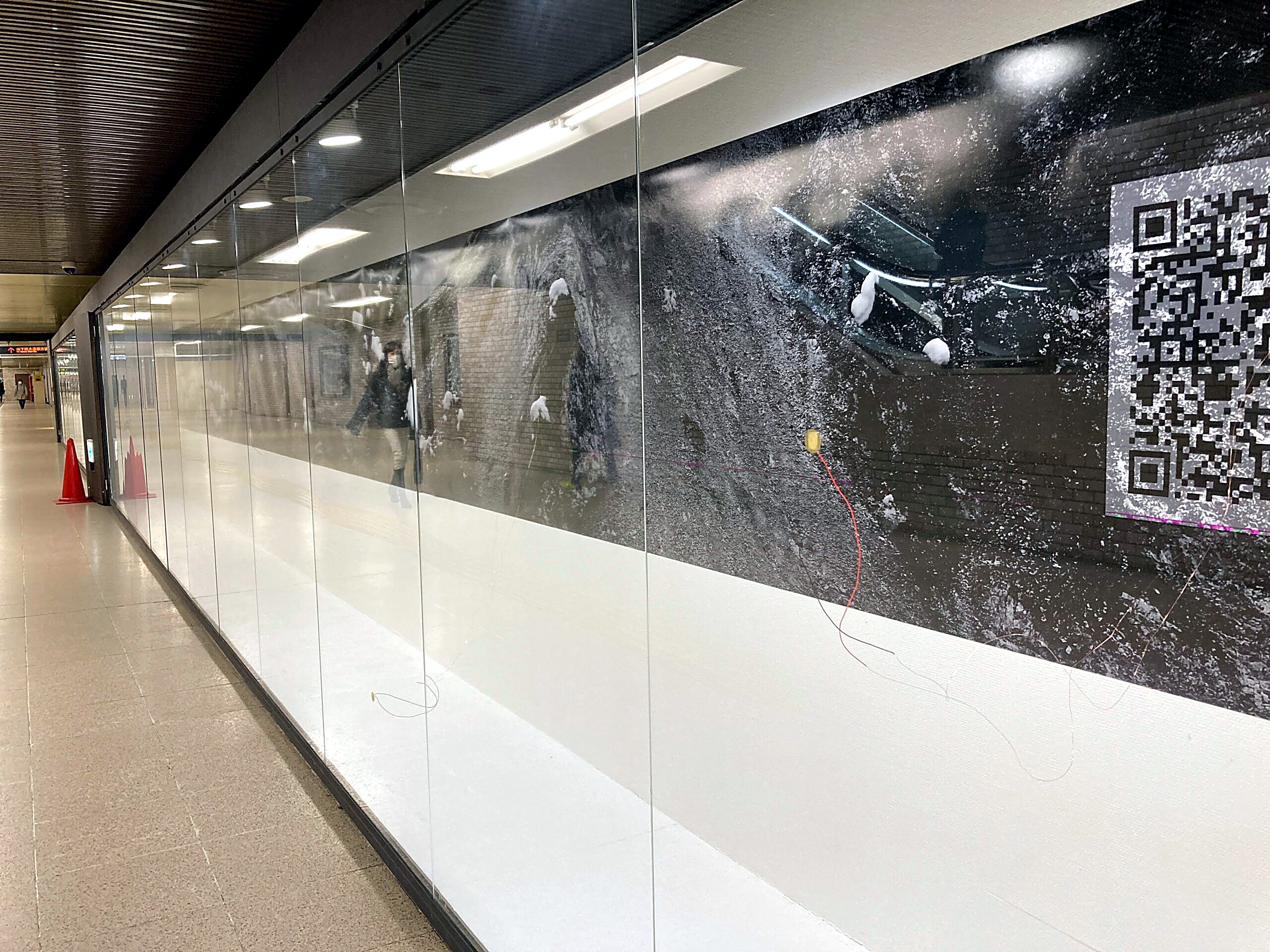 Oblique view along the radio silence installation behind glass in the underground walkway