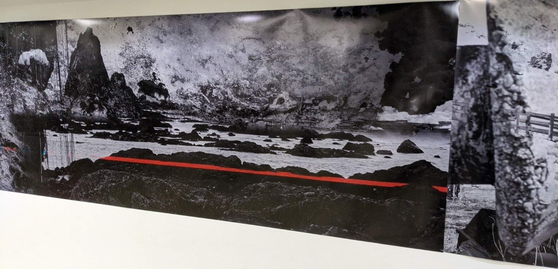 Installation detail showing overlapping rocky coastlines and a red horizontal line
